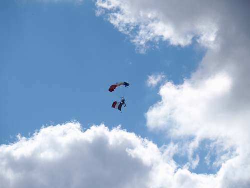 leisure activities man parachuting near clouds gliding